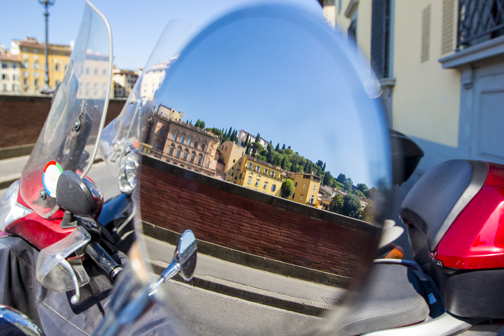 Vistas de Florencia: montañas, cipreses, casas, reflejadas en el espejo retrovisor de la motocicleta estacionada, bicicleta, Florencia, Toscana, Italia